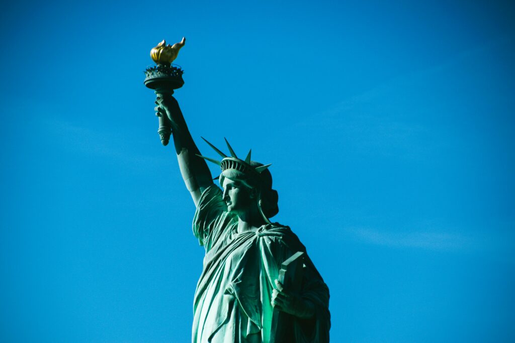 Iconic view of the Statue of Liberty with a bright blue sky, symbolizing freedom in New York. Iconic view of the Statue of Liberty with a bright blue sky, symbolizing freedom in New York.